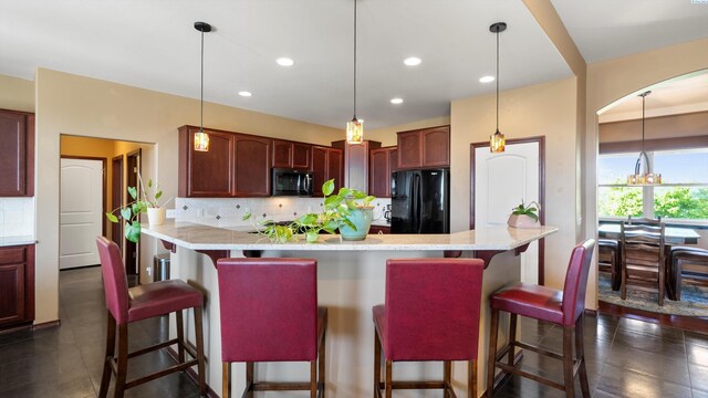 kitchen featuring tasteful backsplash, recessed lighting, freestanding refrigerator, a breakfast bar, and pendant lighting