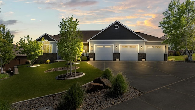 view of front facade with brick siding, a front lawn, driveway, and an attached garage