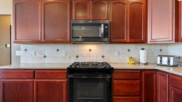 kitchen with stainless steel microwave, dark brown cabinets, black gas range, and tasteful backsplash
