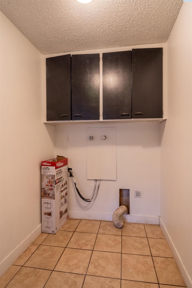 775 S 4th Ave, Othello, WA 99344 - clothes washing area featuring cabinet space, electric dryer hookup, a textured ceiling, light tile patterned floors, and hookup for a washing machine