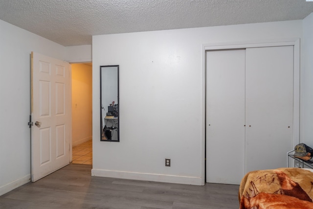 775 S 4th Ave, Othello, WA 99344 - bedroom with wood finished floors, a closet, baseboards, and a textured ceiling