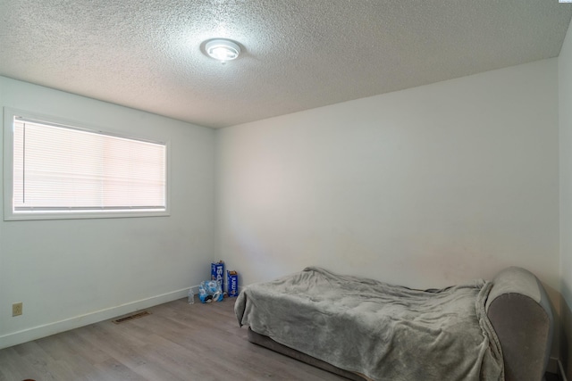 775 S 4th Ave, Othello, WA 99344 - bedroom with wood finished floors, a textured ceiling, and baseboards