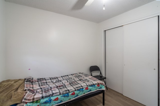 775 S 4th Ave, Othello, WA 99344 - bedroom with wood finished floors, a closet, ceiling fan, and a textured ceiling