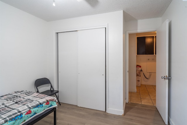 775 S 4th Ave, Othello, WA 99344 - bedroom featuring a closet, light wood-style floors, and a textured ceiling