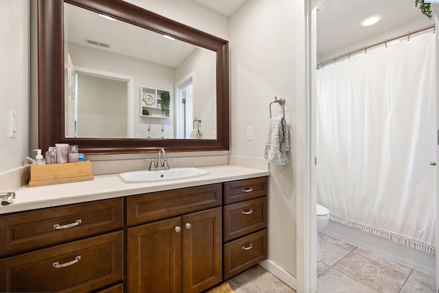 bathroom with tile patterned flooring, toilet, vanity, visible vents, and baseboards