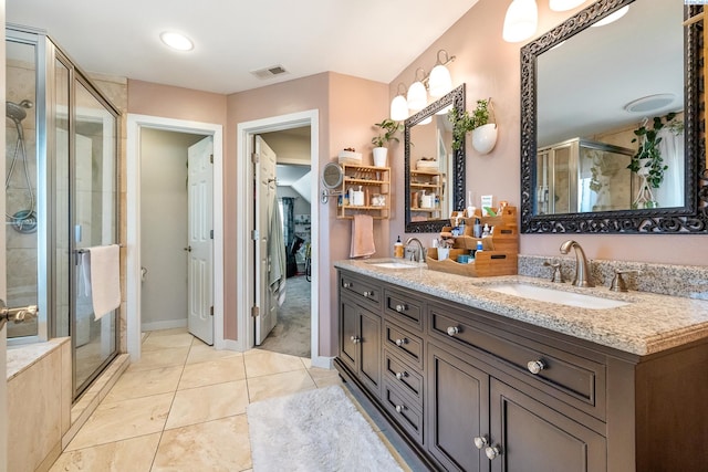 full bathroom with double vanity, a stall shower, a sink, and visible vents