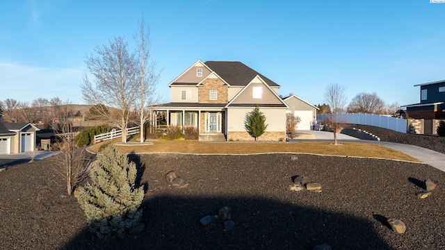 view of front facade with concrete driveway, a porch, and fence