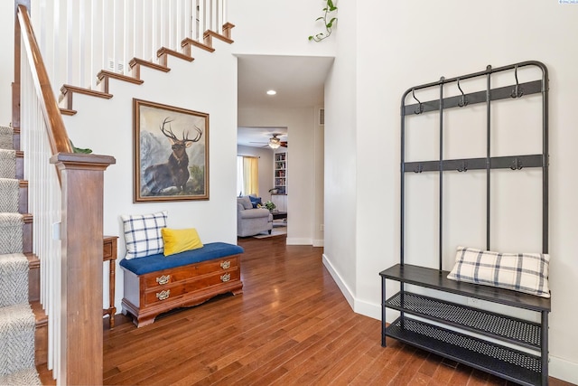 corridor with stairway, wood finished floors, and baseboards