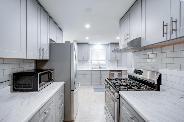1315 NW Haven Cir, Pullman, WA 99163 - kitchen with appliances with stainless steel finishes, a sink, backsplash, under cabinet range hood, and light stone countertops