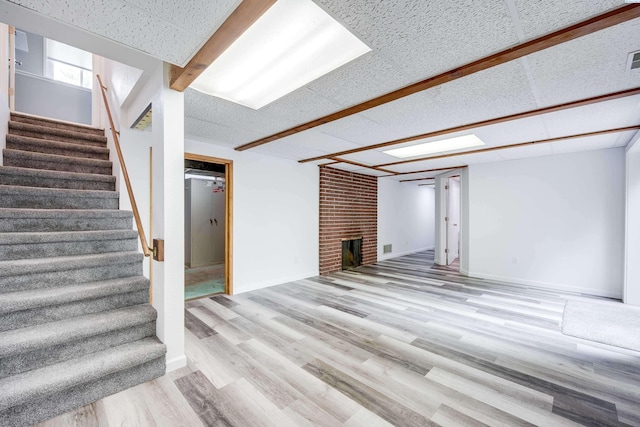 1315 NW Haven Cir, Pullman, WA 99163 - basement featuring stairway, wood finished floors, and a brick fireplace