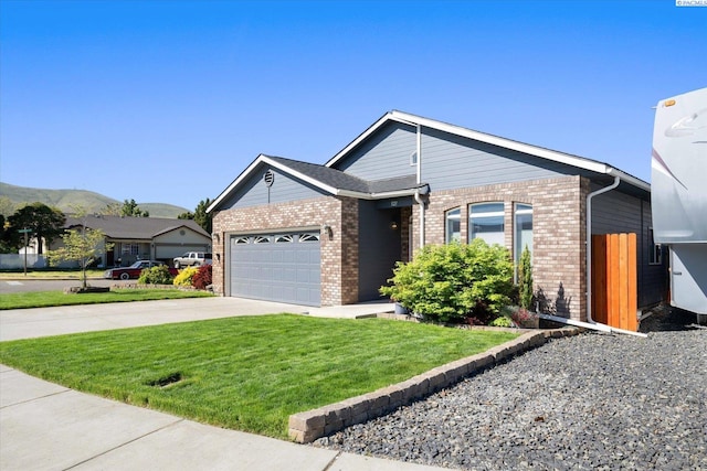 521 Eastgate Dr, Prosser, WA 99350 - ranch-style house featuring driveway, an attached garage, brick siding, a front lawn, and a mountain view