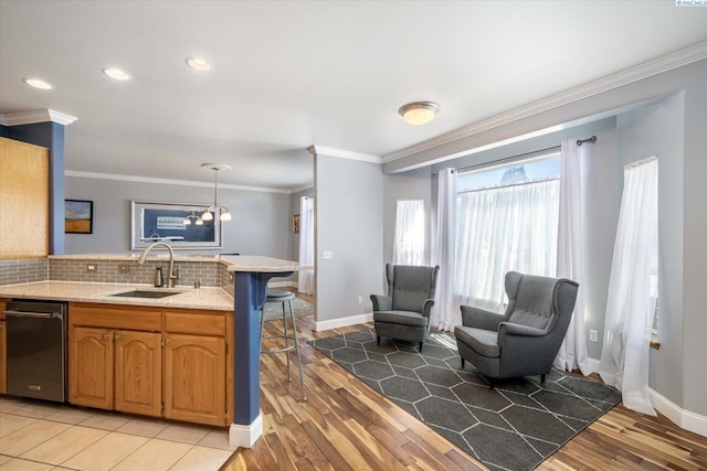 521 Eastgate Dr, Prosser, WA 99350 - kitchen with a sink, a peninsula, stainless steel dishwasher, ornamental molding, and backsplash