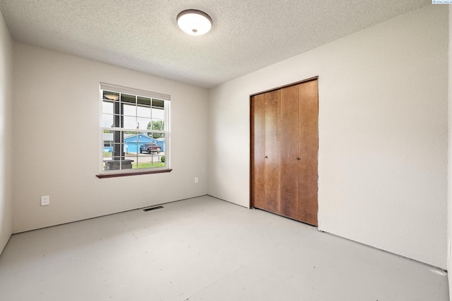 4016 W Ruby, Pasco, WA 99301 - unfurnished bedroom with a textured ceiling, concrete flooring, and a closet