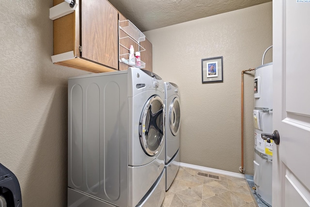 4016 W Ruby, Pasco, WA 99301 - laundry area featuring washing machine and clothes dryer, light tile patterned flooring, a textured wall, cabinet space, and electric water heater