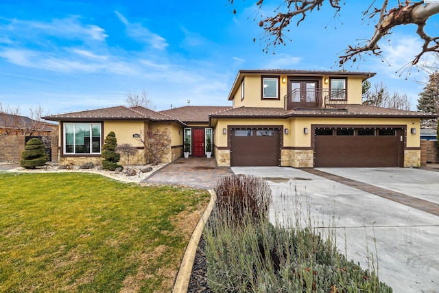 view of front of home with a garage, a front yard, and a balcony