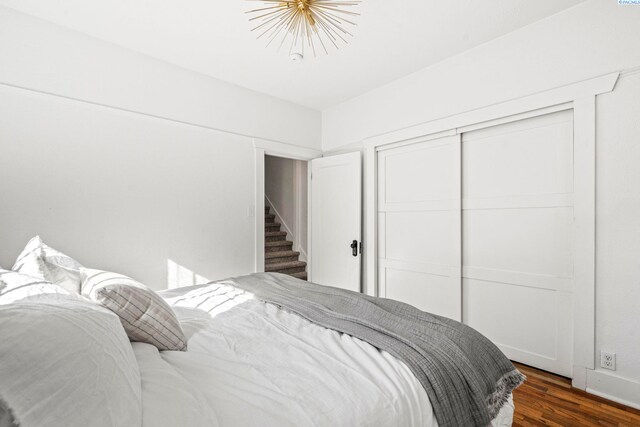 bedroom with dark wood-type flooring and a closet