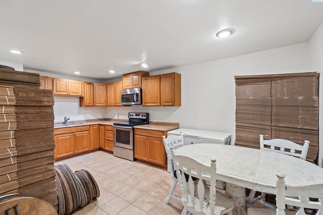 kitchen featuring stainless steel appliances, sink, and light tile patterned floors