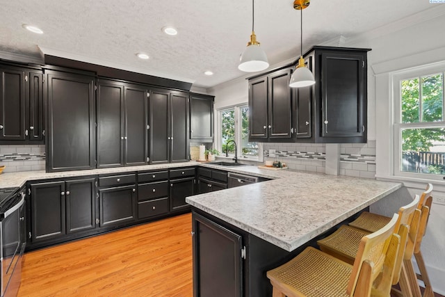 kitchen featuring pendant lighting, sink, a breakfast bar, ornamental molding, and kitchen peninsula