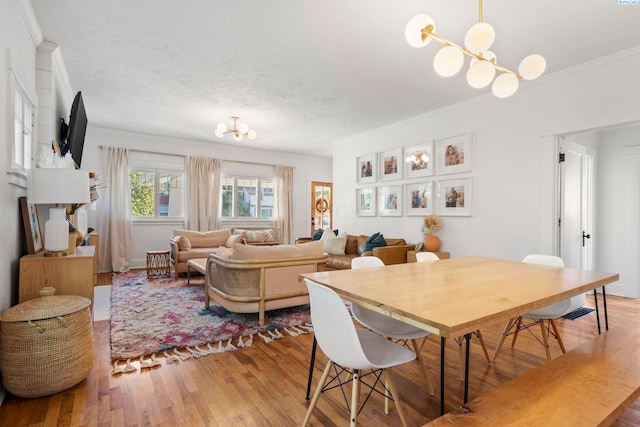 dining room with a notable chandelier, crown molding, and wood-type flooring