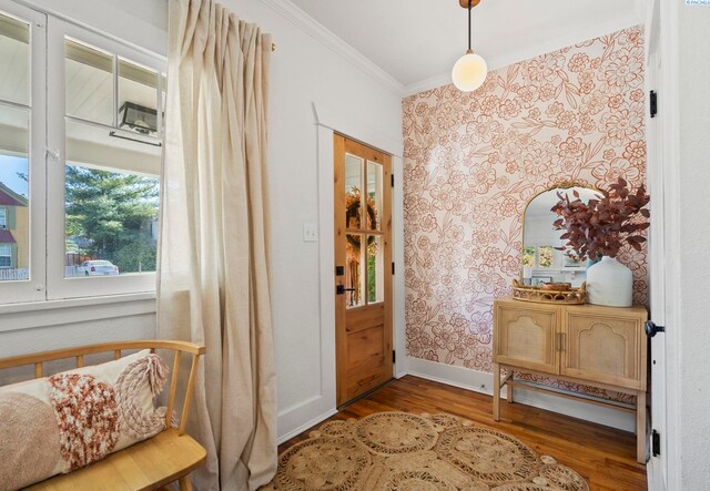 doorway to outside with ornamental molding and wood-type flooring