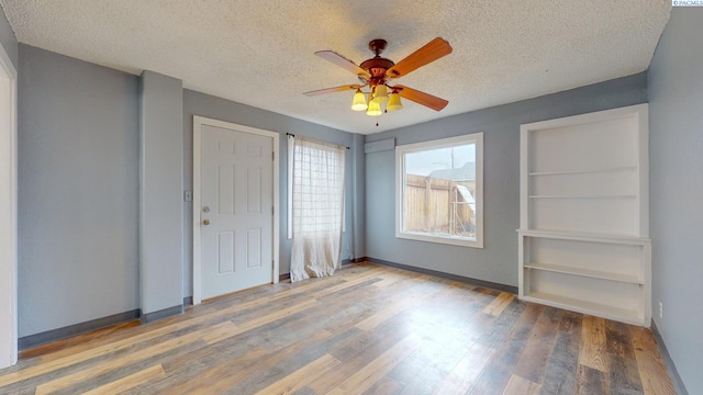 unfurnished bedroom with wood-type flooring, ceiling fan, and a textured ceiling