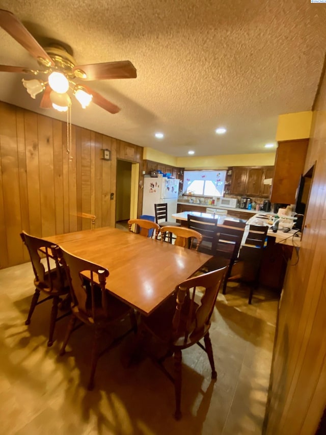 dining room with wooden walls and a textured ceiling