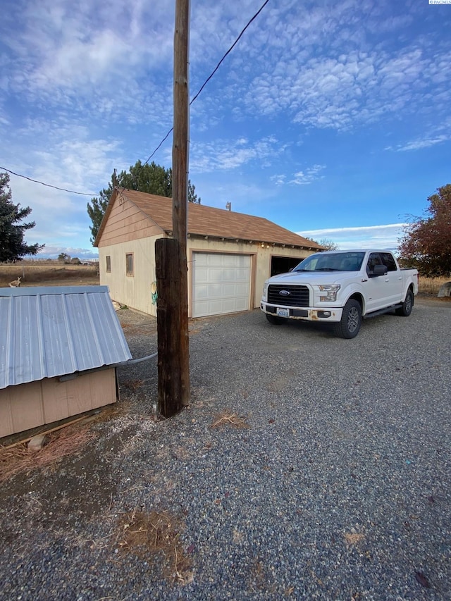 view of home's exterior with a garage and gravel driveway