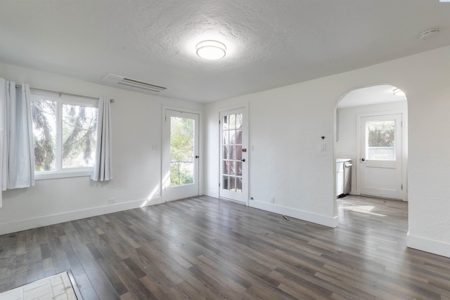 615 SW Winter Cir, Pullman, WA 99163 - empty room featuring arched walkways, healthy amount of natural light, wood finished floors, and a textured ceiling