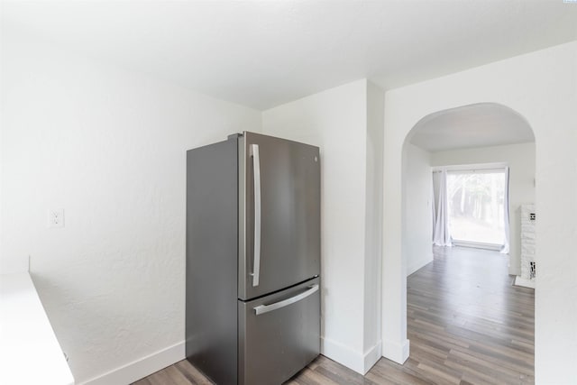 615 SW Winter Cir, Pullman, WA 99163 - kitchen with freestanding refrigerator, arched walkways, wood finished floors, and baseboards