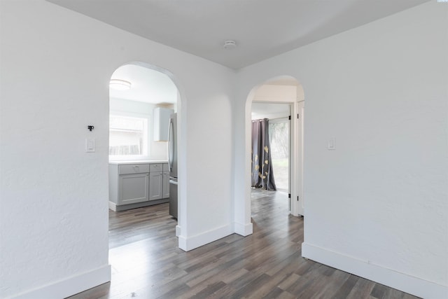 615 SW Winter Cir, Pullman, WA 99163 - empty room featuring dark wood-type flooring, arched walkways, a smoke detector, and baseboards