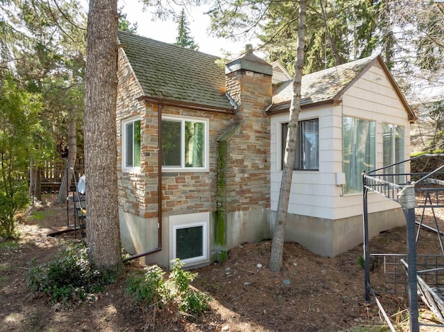 615 SW Winter Cir, Pullman, WA 99163 - view of property exterior featuring a chimney, roof with shingles, and stone siding