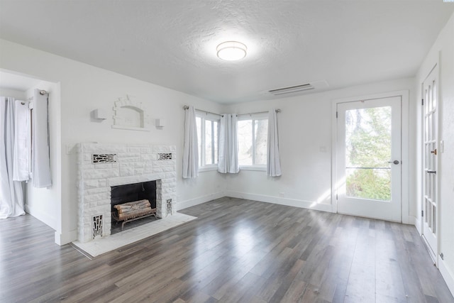 615 SW Winter Cir, Pullman, WA 99163 - unfurnished living room with a fireplace, plenty of natural light, wood finished floors, baseboards, and a textured ceiling