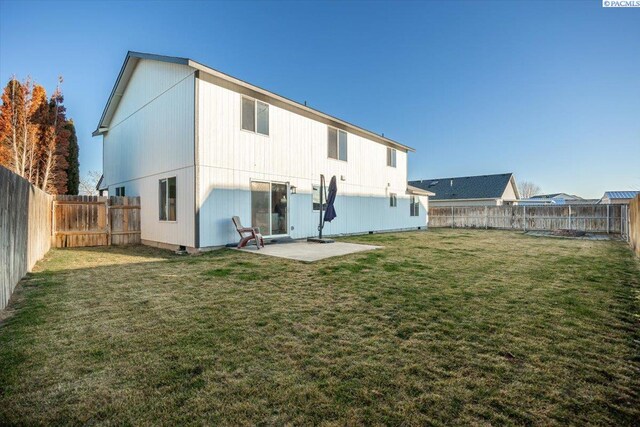 back of house featuring a patio and a lawn