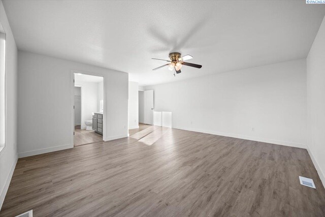 unfurnished living room featuring ceiling fan and wood-type flooring