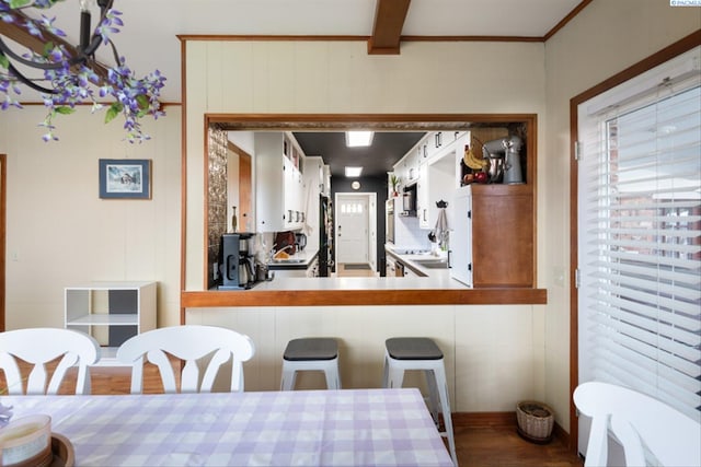 dining room featuring beam ceiling and hardwood / wood-style flooring