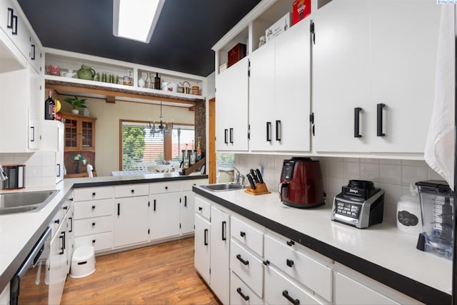 kitchen featuring dishwasher, sink, and white cabinets