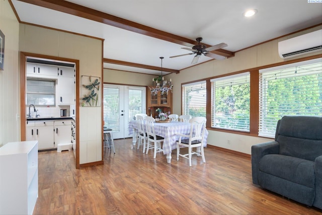 dining space with an AC wall unit, ceiling fan with notable chandelier, beamed ceiling, wood-type flooring, and sink