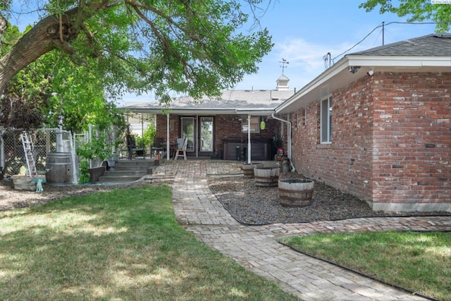 back of house with a patio and a yard