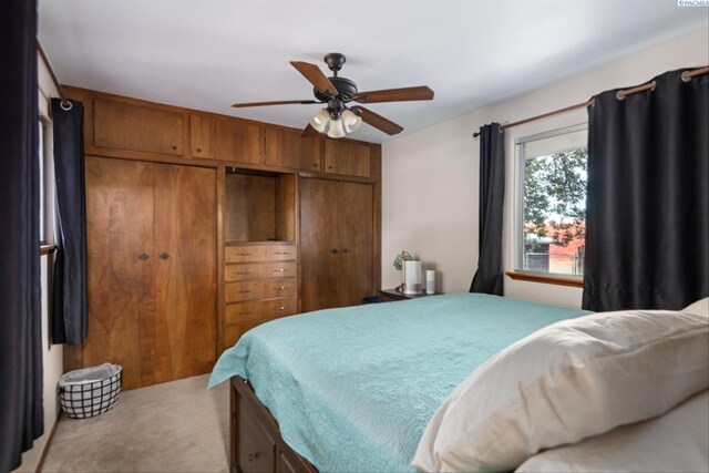 carpeted bedroom featuring ceiling fan and a closet