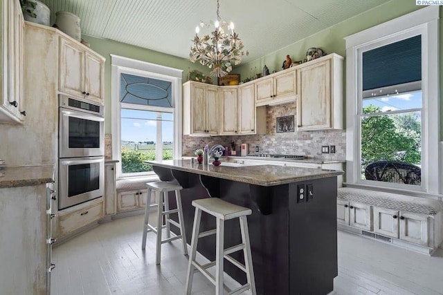 257 N Wamba Rd, Prosser, WA 99350 - kitchen featuring stainless steel double oven, light brown cabinetry, backsplash, a chandelier, and a center island