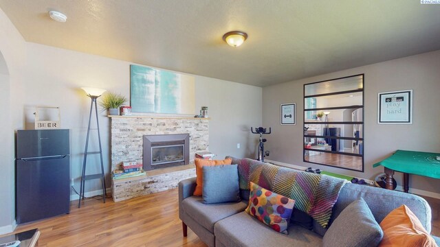 living area featuring a fireplace, baseboards, and light wood-type flooring