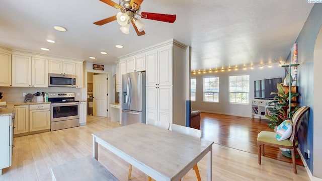 kitchen with recessed lighting, a ceiling fan, light wood finished floors, and stainless steel appliances