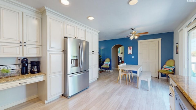 kitchen with a ceiling fan, white dishwasher, stainless steel refrigerator with ice dispenser, arched walkways, and light wood-style flooring