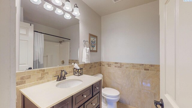 bathroom featuring visible vents, tile walls, vanity, toilet, and a shower with shower curtain