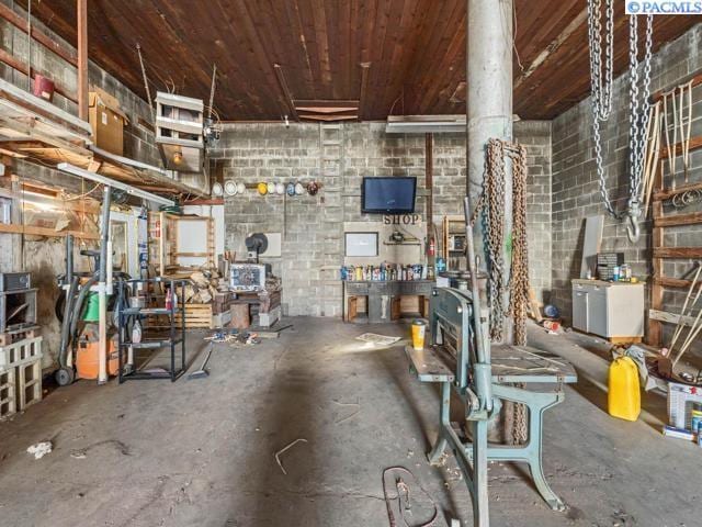 miscellaneous room with concrete flooring and wooden ceiling