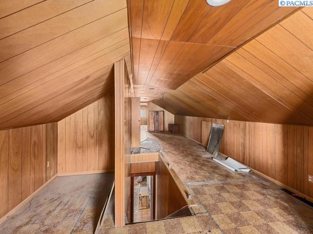 additional living space featuring wooden ceiling, vaulted ceiling, and wood walls