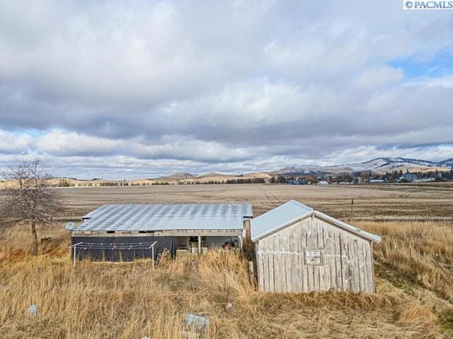 view of outbuilding featuring a mountain view and a rural view