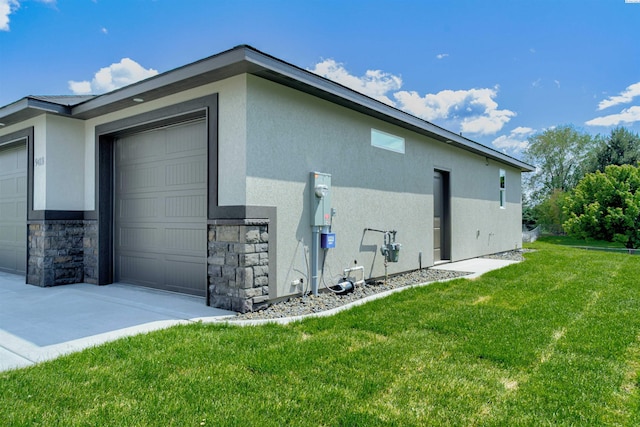 9418 Balflour Ct, Pasco, WA 99301 - view of side of home featuring stucco siding, a lawn, a garage, and stone siding