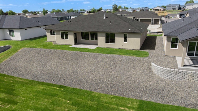 9418 Balflour Ct, Pasco, WA 99301 - back of house with a residential view, a patio area, roof with shingles, stucco siding, and a lawn