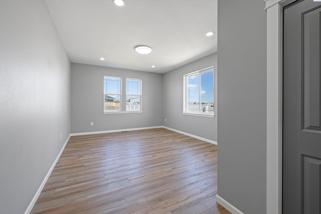 spare room featuring plenty of natural light and light hardwood / wood-style flooring